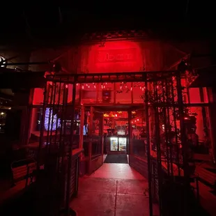  the entrance to a bar lit up with red lights