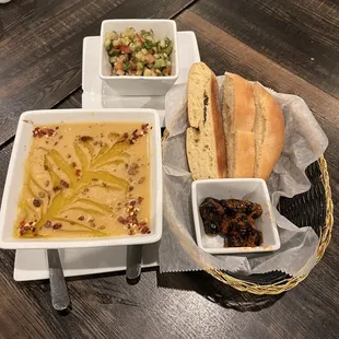 a bowl of soup, bread, and a bowl of salad