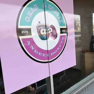 a sign in the window of a donut shop