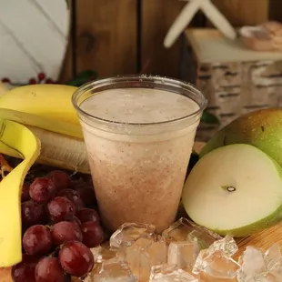 a banana, grapes, and pear on a cutting board