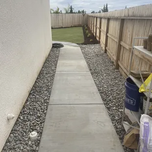 a concrete walkway in a back yard
