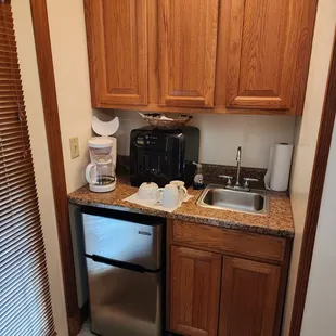 Kitchenette, with refrigerator, microwave, coffee machine and sink.