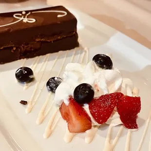 a piece of chocolate cake with strawberries and blueberries