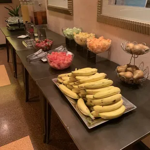 a table of bananas and other fruits