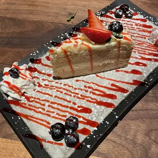 a slice of cheesecake with strawberries and blueberries