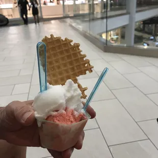 a person holding a waffle and ice cream