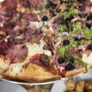 a hand holding a pizza