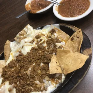a plate of nachos and a bowl of salsa