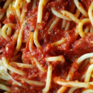 The bed of spaghetti with loose sauce on the bottom