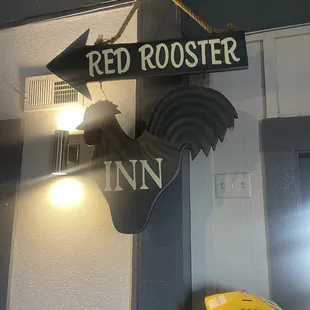 a rooster hanging from a sign