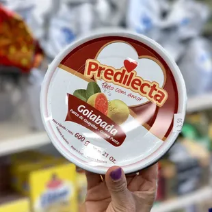 a person holding a container of fruit ice cream