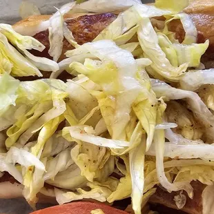 a hot dog with lettuce and tomatoes