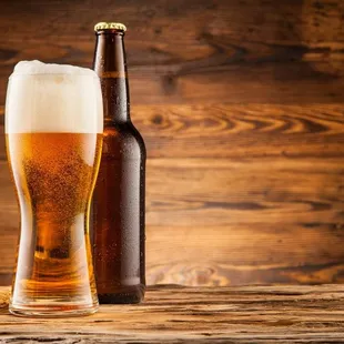 a glass of beer next to a bottle of beer