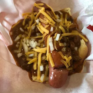 a chili dog with cheese and onions