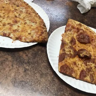 two slices of pizza on paper plates