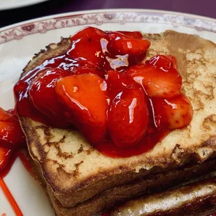 a stack of french toast with strawberries on top