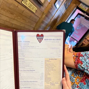 a woman holding a menu