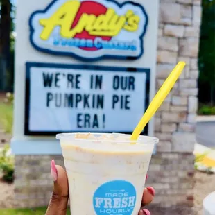 a hand holding a cup of frozen custard