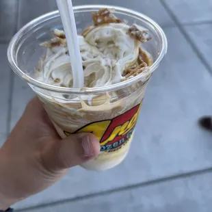 a hand holding a cup of ice cream