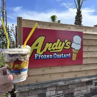 a hand holding a cup of ice cream