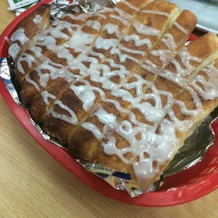 Cinnamon sticks. Pizza crust with cinnamon sugar and frosting.