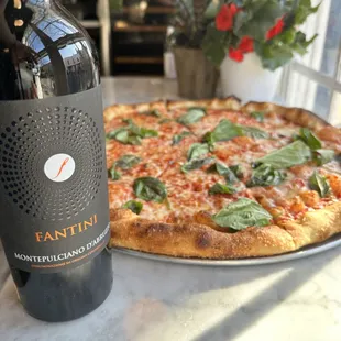 a pizza and a bottle of wine