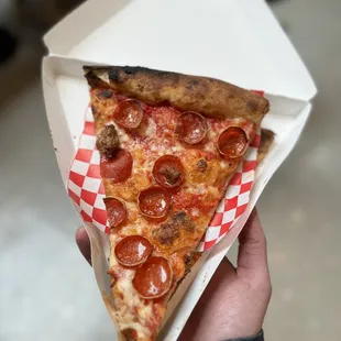 Pepperoni and sausage pizza slice