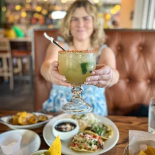a woman holding a margarita