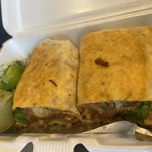 two burritos in a styrofoam container