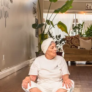 a woman sitting on a yoga mat in a living room