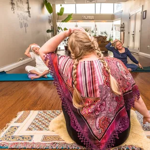a woman sitting on a rug in a yoga class