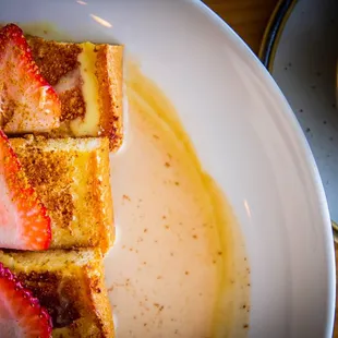 Horchata French Toast; fluffy brioche bread, a hint of cinnamon, dusted with powdered sugar, and topped with fresh strawberries.