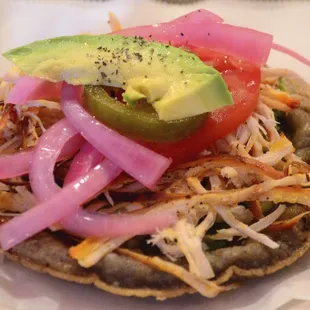 Chicken panucho with cabbage, pickled red onion and an avocado slice. Delicious.