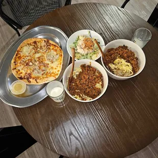 a wooden table with bowls of food on it