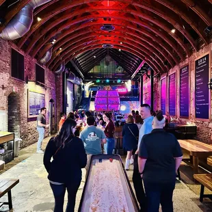 a group of people standing around a shuffle table