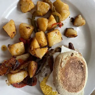 Sausage, egg and cheese sandwich on English muffin with potatoes