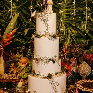 a three tiered cake with figurines on top