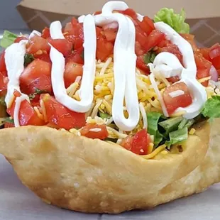 a taco salad with lettuce and tomatoes