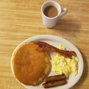 a breakfast of pancakes, eggs, bacon and sausage