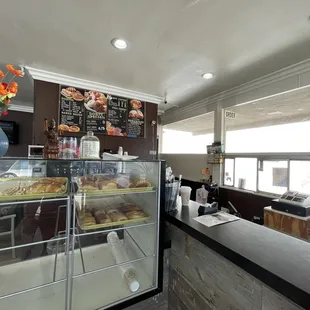 a bakery counter with a glass case full of donuts