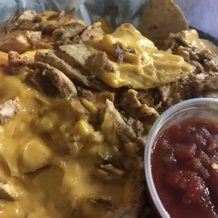 a plate of nachos with cheese and sauce