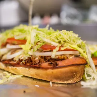 a sandwich with lettuce and tomatoes