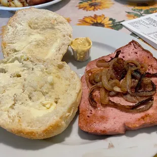 Fried Fleischkäse with grilled onions and a buttered brötchen. You can add a fried egg to make it a breakfast sandwich.