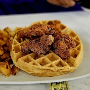 Chicken tenders and waffle with a side of potatoes