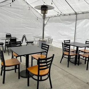 tables and chairs under a tent