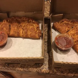 two boxes of pizza with condiments