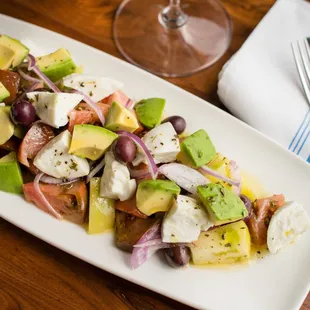 Insalata Di Pomodoro; Heirloom tomatoes, fresh mozzarella, avocado, buffalo mozzarella, red onion, Taggiasca olives, oregano, EVOO