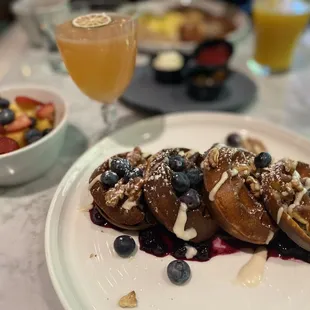 a plate of french toast with blueberries and strawberries