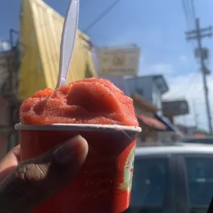 a hand holding a cup of ice cream