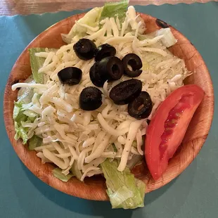 a plate of salad with black olives and lettuce
